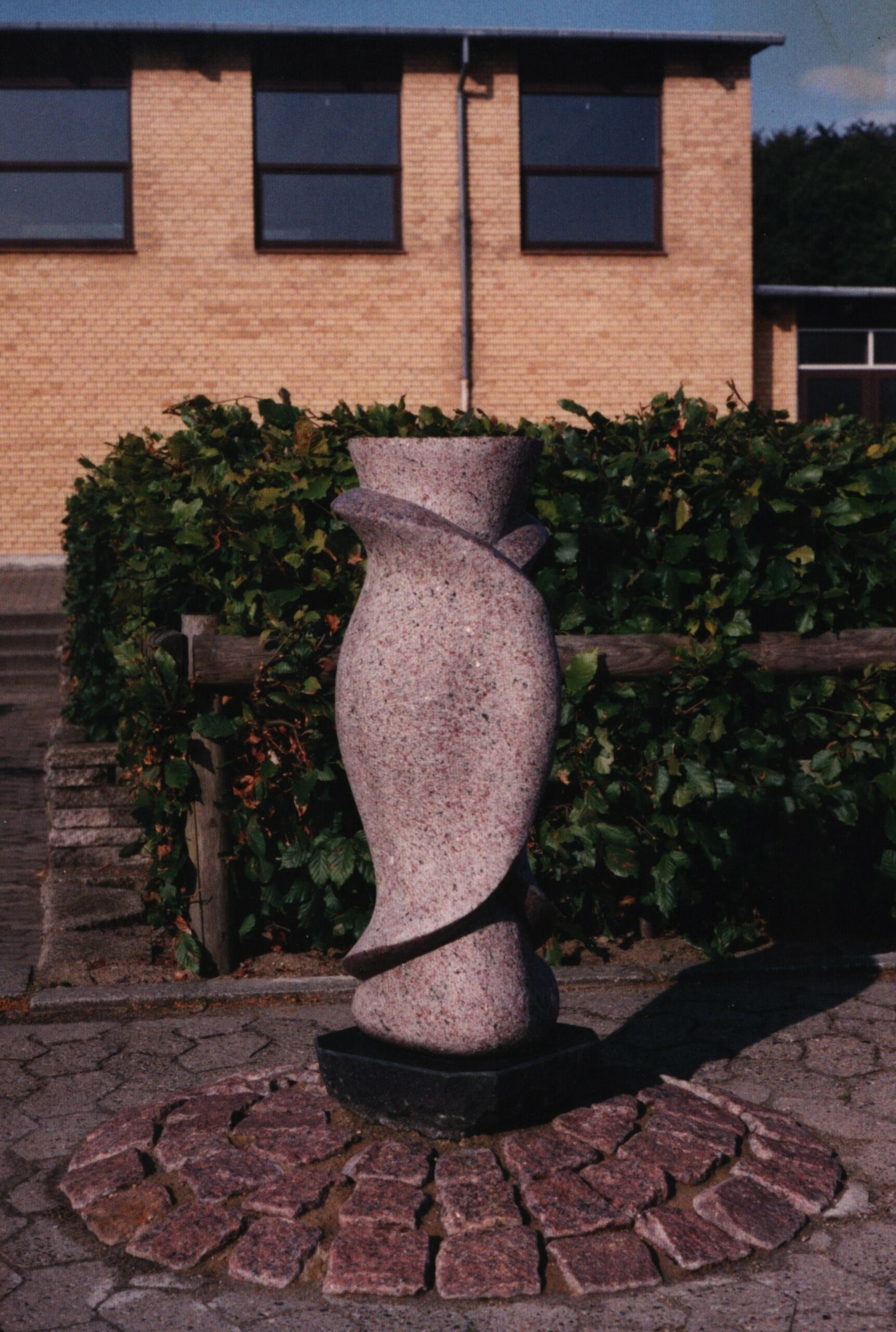 Det vi ikke ved . Skulptur, granit. Steen Krarup Jensen. Del af udsmykningen Herfra Min verden går. Hou Skole. Dateret 1993.